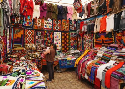 woman in store with display of assorted shirts and textiles